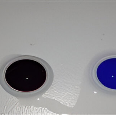 Two round paint containers on a white surface, one filled with dark maroon paint and the other with blue paint.