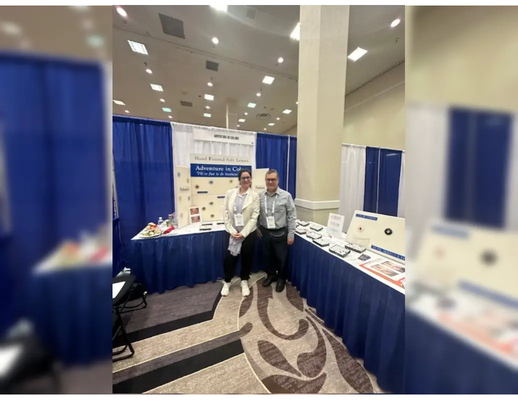 Two men standing in front of a blue table.