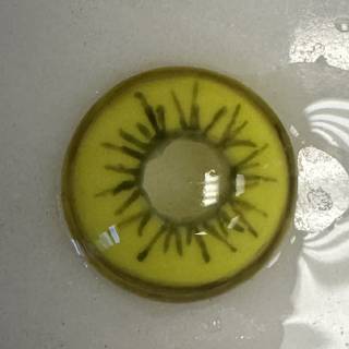 A close up of an eye with a kiwi on it