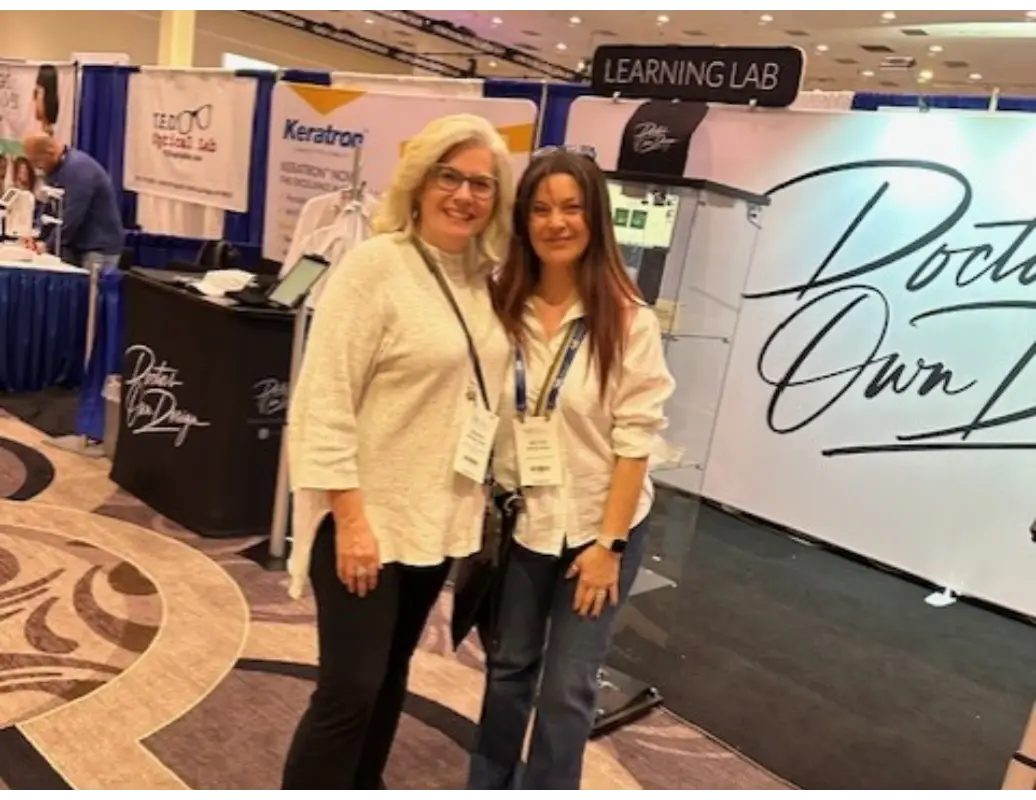 Two women posing for a picture in front of a learning lab sign.