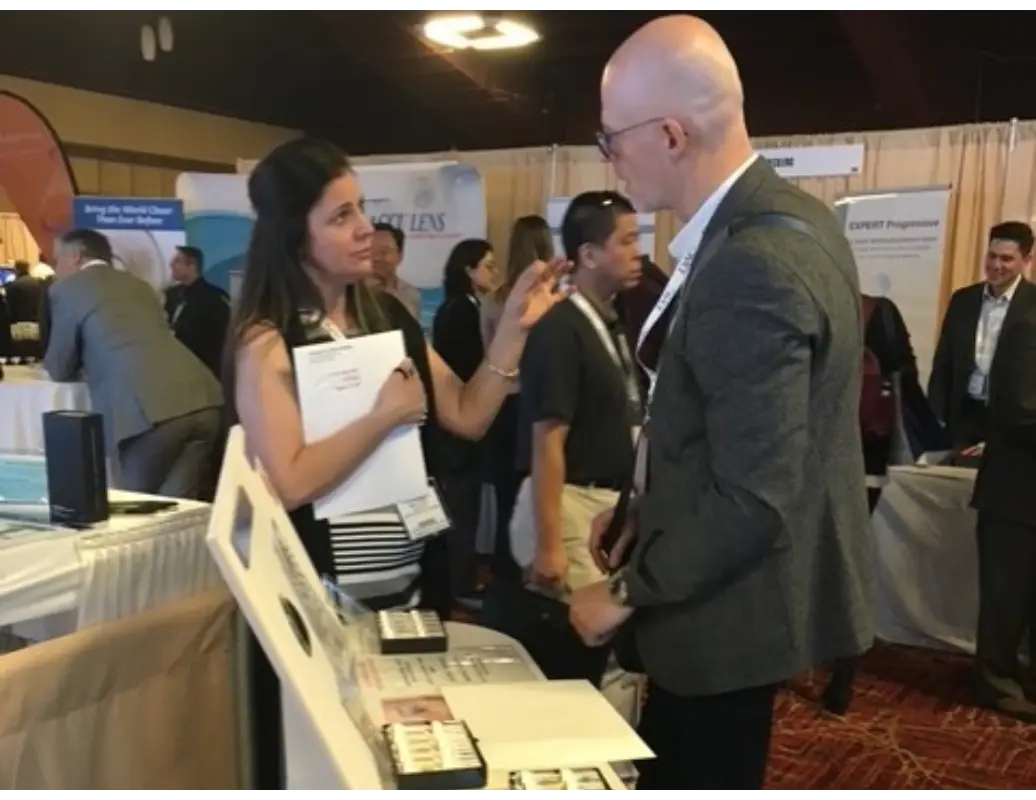 A woman talking to a man at an event.